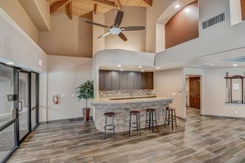 A modern kitchen with a bar and stools. at San Montego Apartments, Mesa